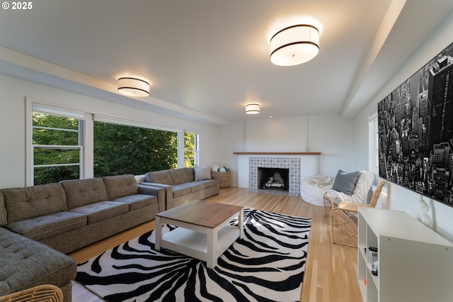 living room featuring a tiled fireplace and hardwood / wood-style flooring