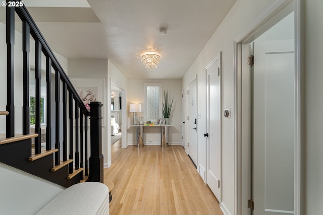 foyer featuring light hardwood / wood-style floors, a textured ceiling, a chandelier, and plenty of natural light