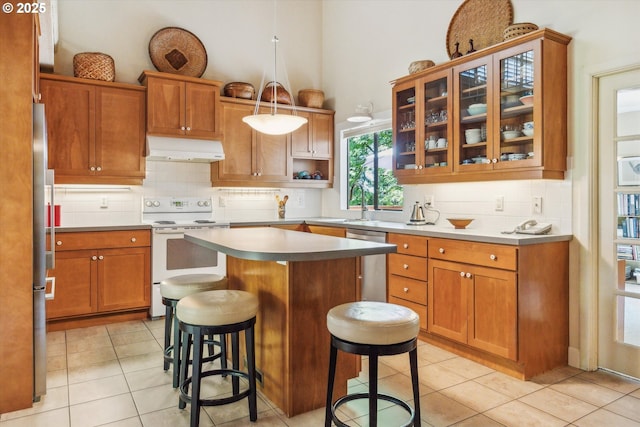15 Cellini Ct, Lake Oswego, OR 97035 - kitchen featuring appliances with stainless steel finishes, under cabinet range hood, backsplash, a breakfast bar, and a kitchen island