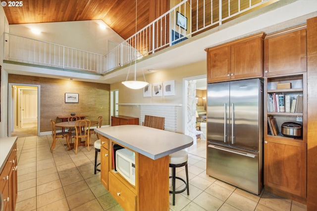 15 Cellini Ct, Lake Oswego, OR 97035 - kitchen featuring high end fridge, wood ceiling, high vaulted ceiling, light tile patterned floors, and a kitchen bar