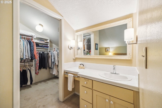 15 Cellini Ct, Lake Oswego, OR 97035 - bathroom with vanity, a spacious closet, a textured ceiling, and vaulted ceiling