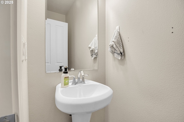 bathroom with a sink and a textured wall