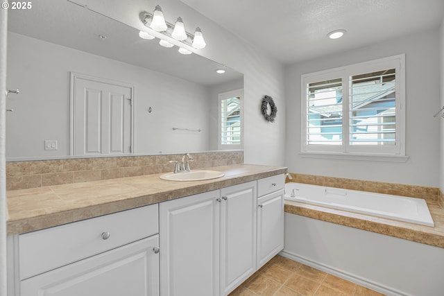 bathroom with vanity, a garden tub, and recessed lighting