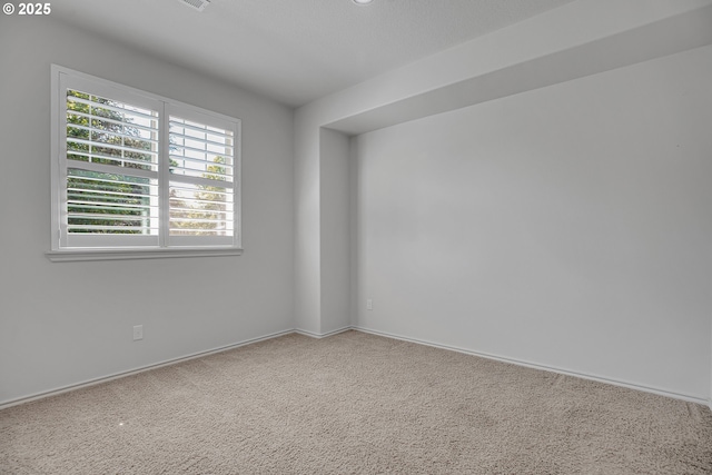 spare room featuring baseboards and carpet