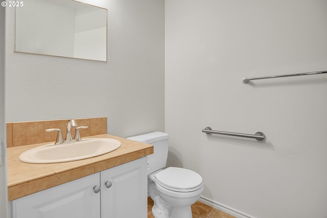 half bathroom with vanity, tile patterned flooring, and toilet