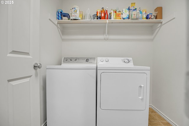 clothes washing area with laundry area, baseboards, and washing machine and clothes dryer