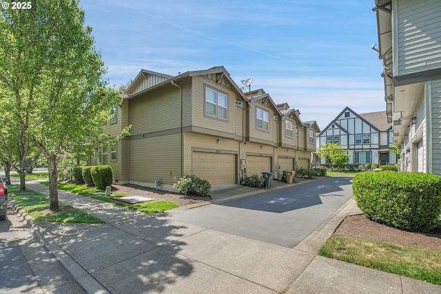 view of home's exterior with board and batten siding, an attached garage, driveway, and a residential view
