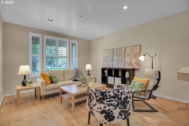 living room with recessed lighting, baseboards, and light wood finished floors