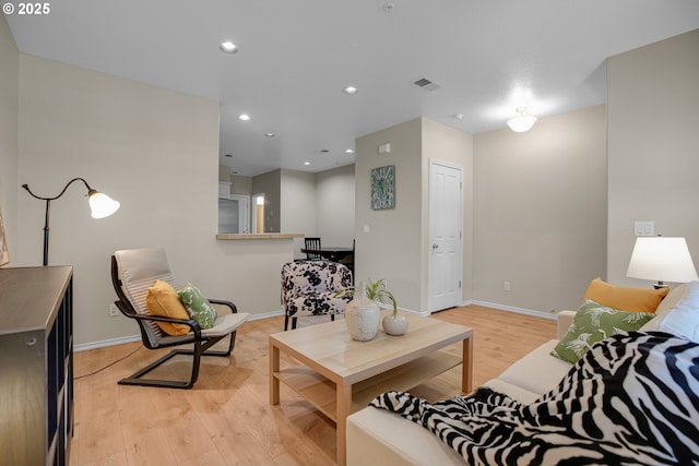 living area with recessed lighting, baseboards, light wood finished floors, and visible vents
