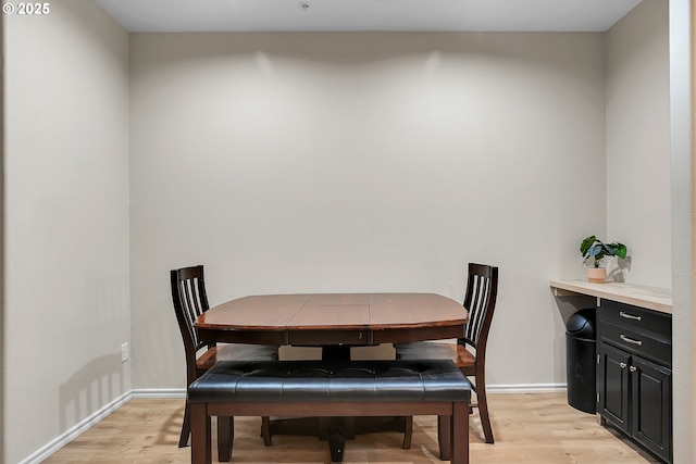 dining area featuring baseboards and light wood-style floors