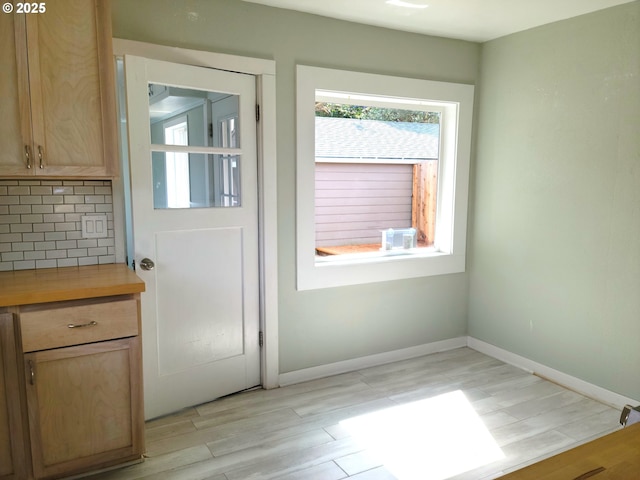 entryway with baseboards and light wood-style flooring