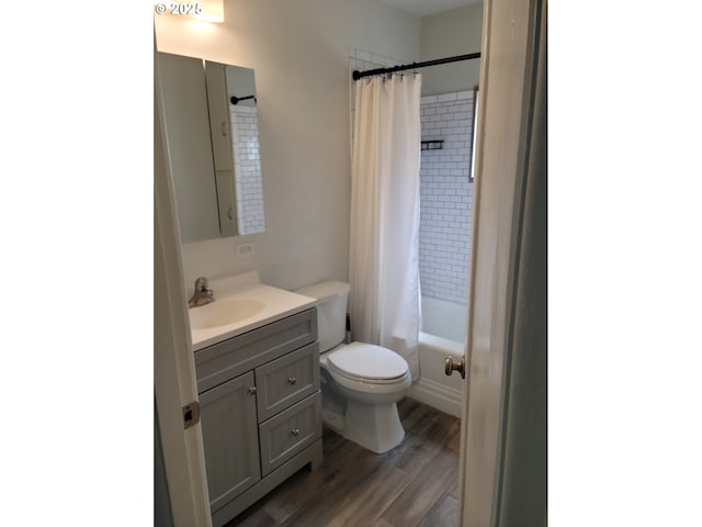 bathroom with vanity, shower / bath combo with shower curtain, toilet, and wood finished floors