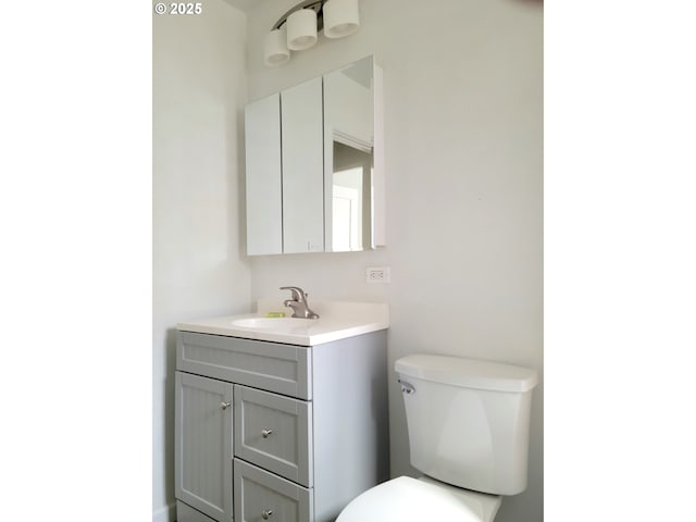 half bathroom featuring toilet and vanity