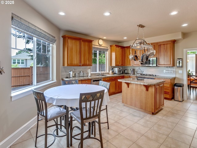 7913 SW Leiser Ln, Portland, OR 97224 - kitchen with appliances with stainless steel finishes, tasteful backsplash, recessed lighting, a kitchen island, and brown cabinets