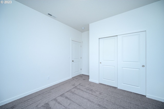 unfurnished bedroom with a closet and carpet flooring