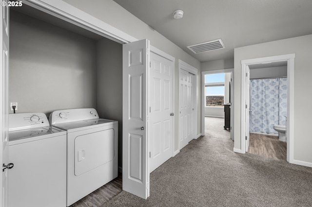 laundry area featuring dark carpet and washing machine and clothes dryer