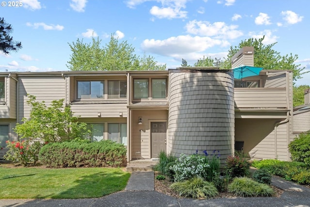 townhome / multi-family property featuring a front lawn