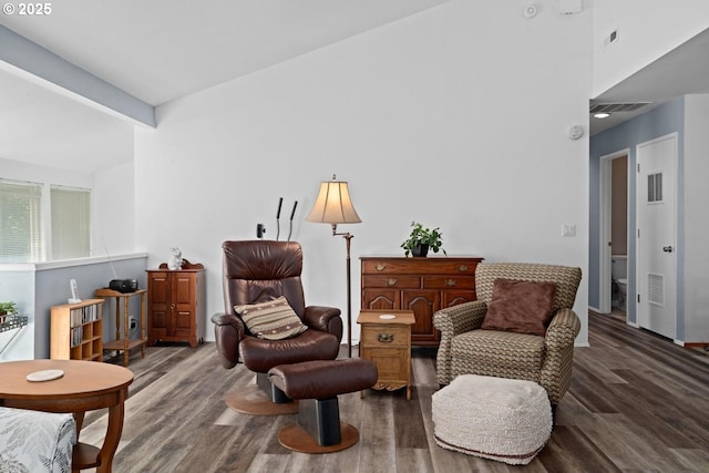 sitting room with wood finished floors and beamed ceiling