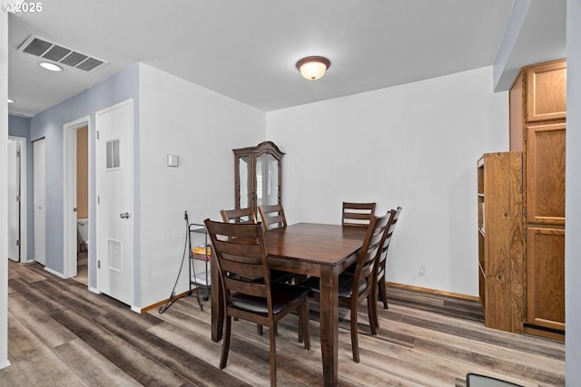 dining space featuring wood finished floors, baseboards, and recessed lighting