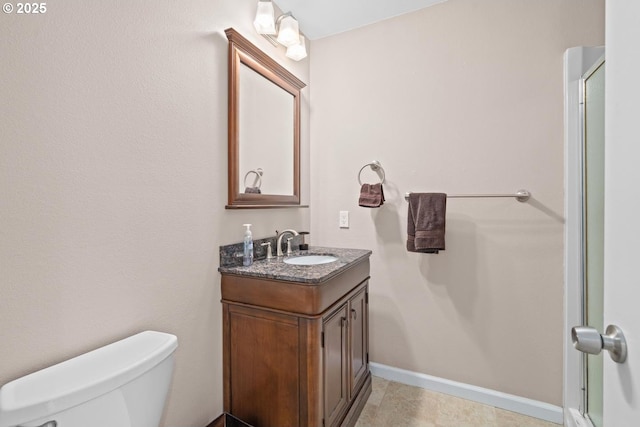 bathroom with vanity, toilet, and baseboards
