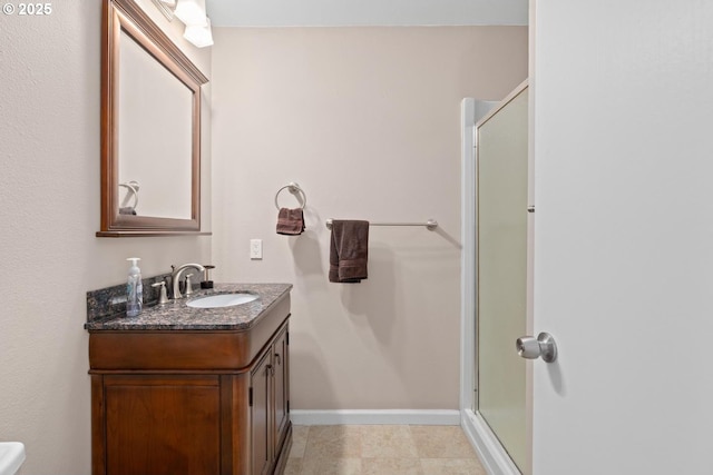 full bathroom with vanity, a stall shower, and baseboards