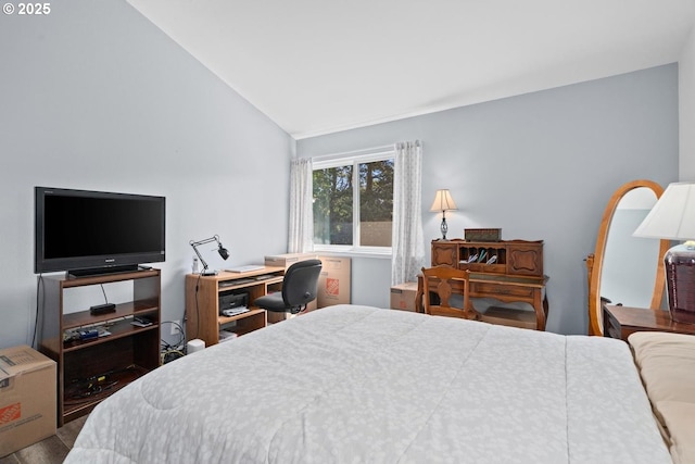 bedroom with lofted ceiling and a desk