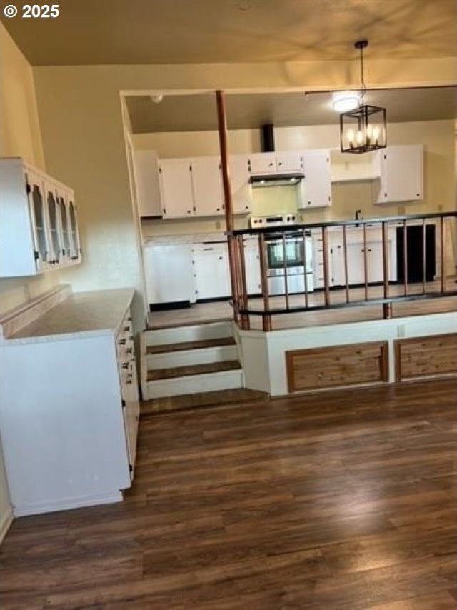 1127 6th Ave, Albany, OR 97321 - kitchen featuring stainless steel electric range oven, white cabinetry, dark wood-style floors, and hanging light fixtures