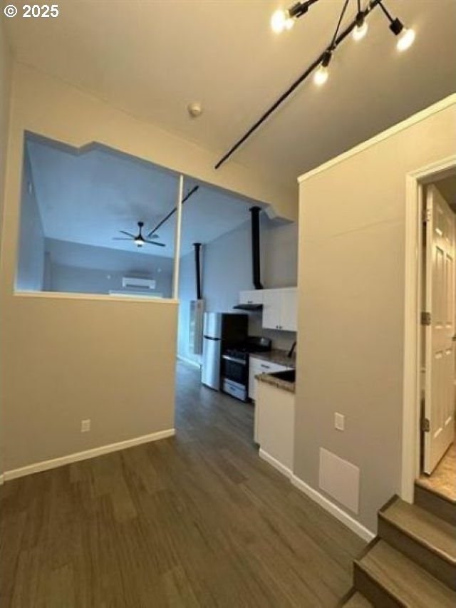 1127 6th Ave, Albany, OR 97321 - kitchen with range with gas stovetop, dark wood-style flooring, a ceiling fan, white cabinetry, and freestanding refrigerator