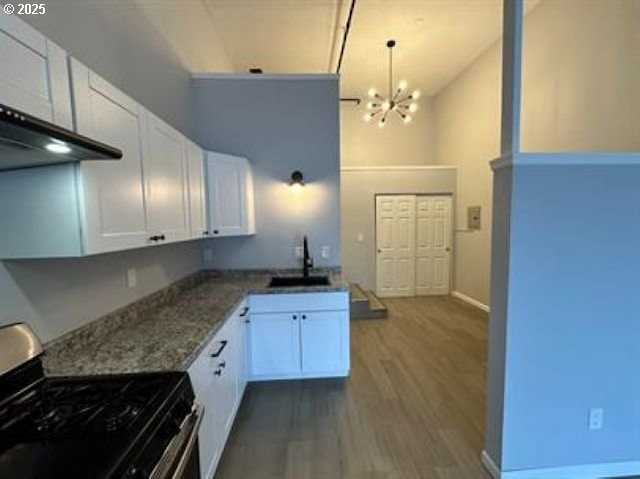 1127 6th Ave, Albany, OR 97321 - kitchen featuring gas stove, a chandelier, dark wood-style flooring, white cabinets, and high vaulted ceiling