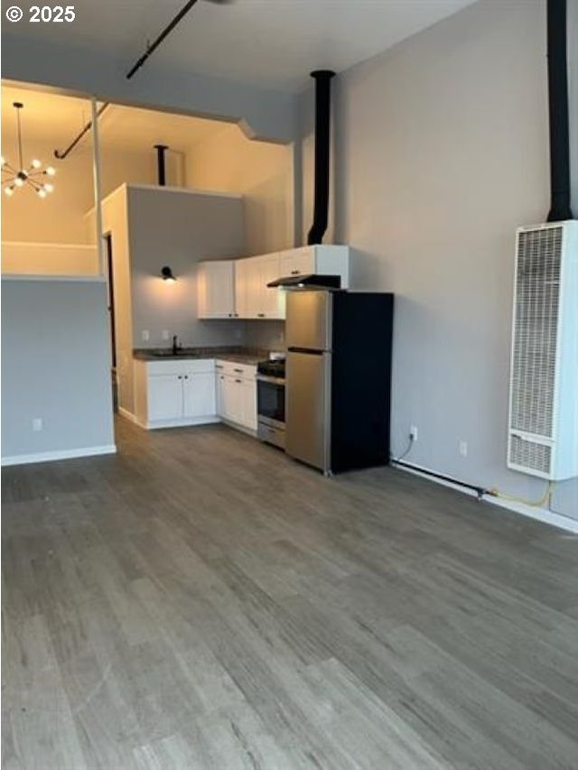 1127 6th Ave, Albany, OR 97321 - kitchen featuring freestanding refrigerator, a heating unit, stove, dark countertops, and white cabinets