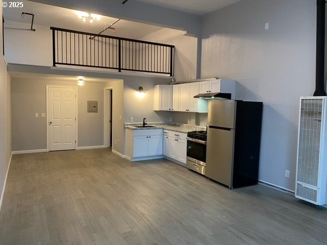 1127 6th Ave, Albany, OR 97321 - kitchen featuring stainless steel appliances, a heating unit, under cabinet range hood, white cabinets, and high vaulted ceiling