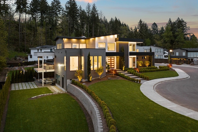 750 NE Province Ct, Camas, WA 98607 - back of property at dusk featuring a lawn, an attached garage, and a balcony