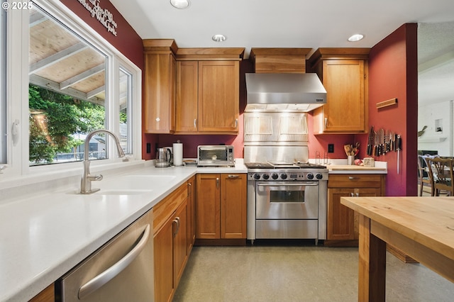 19985 SW Carlin Blvd, Beaverton, OR 97078 - kitchen with appliances with stainless steel finishes, wall chimney exhaust hood, brown cabinetry, and recessed lighting