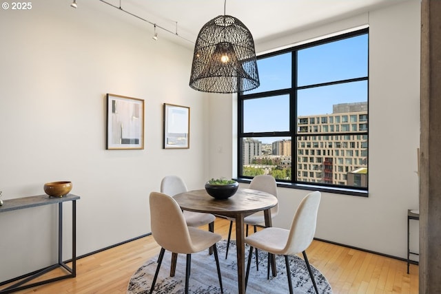 dining room with rail lighting, a chandelier, and light wood-type flooring