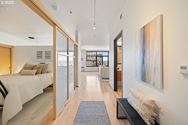 bedroom with track lighting and light wood-type flooring