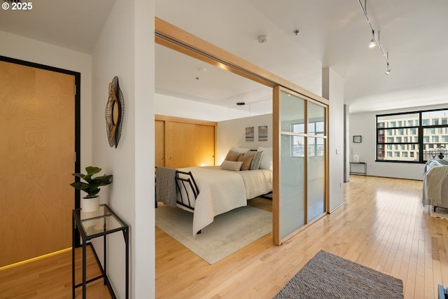 bedroom featuring hardwood / wood-style flooring and rail lighting