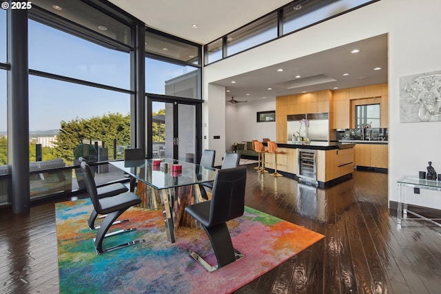 1551 SW Upper Hall St, Portland, OR 97201 - dining area with beverage cooler, dark wood-type flooring, expansive windows, a towering ceiling, and wet bar