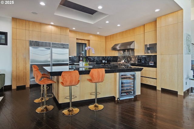 1551 SW Upper Hall St, Portland, OR 97201 - kitchen featuring beverage cooler, built in appliances, wall chimney range hood, light brown cabinetry, and recessed lighting
