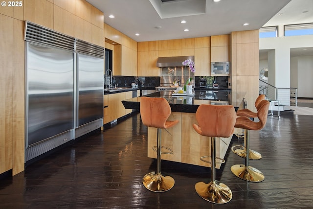 1551 SW Upper Hall St, Portland, OR 97201 - kitchen with built in appliances, light brown cabinetry, dark countertops, modern cabinets, and recessed lighting