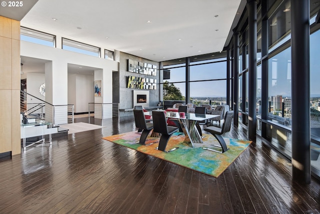 1551 SW Upper Hall St, Portland, OR 97201 - dining area featuring wood-type flooring, floor to ceiling windows, stairs, a fireplace, and a high ceiling