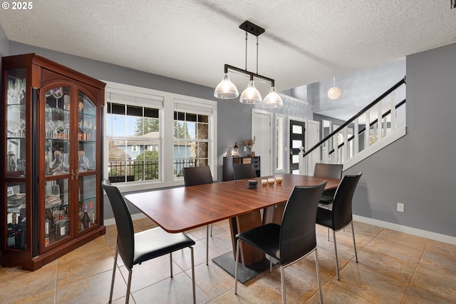 7820 SE 114th Ave, Portland, OR 97266 - dining space with baseboards, a textured ceiling, and stairs