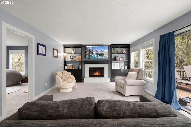7820 SE 114th Ave, Portland, OR 97266 - living room with a textured ceiling, a glass covered fireplace, carpet flooring, baseboards, and built in features