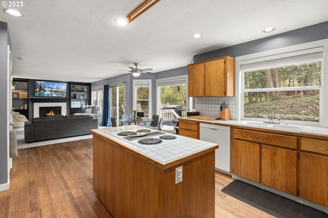 7820 SE 114th Ave, Portland, OR 97266 - kitchen featuring white appliances, tile countertops, a sink, a textured ceiling, and a lit fireplace