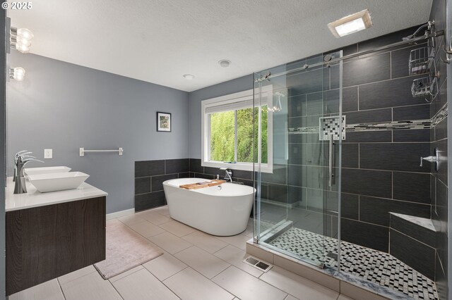 7820 SE 114th Ave, Portland, OR 97266 - bathroom with a freestanding bath, a shower stall, double vanity, tile walls, and tile patterned floors