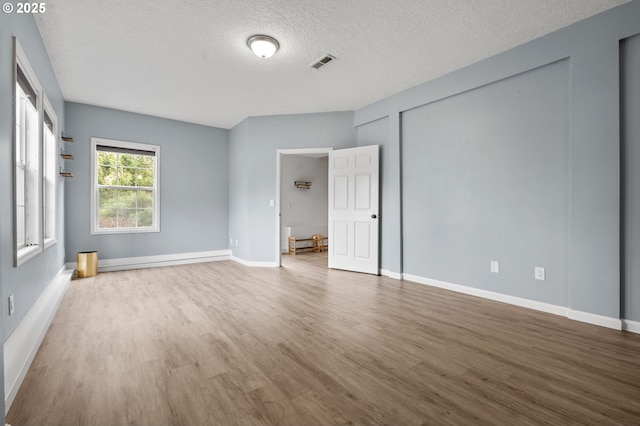 7820 SE 114th Ave, Portland, OR 97266 - unfurnished bedroom with wood finished floors, a textured ceiling, and baseboards