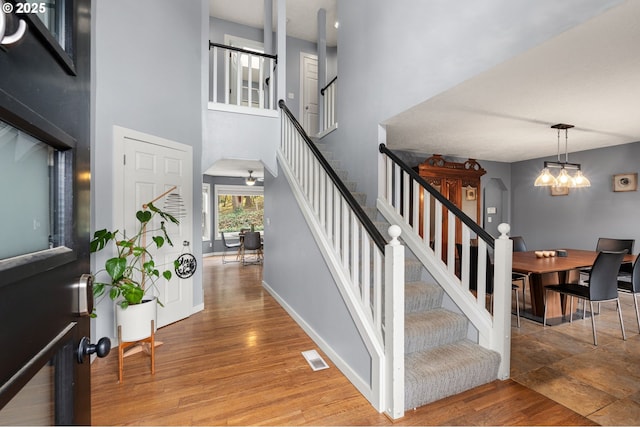 7820 SE 114th Ave, Portland, OR 97266 - stairs with a chandelier, wood finished floors, baseboards, and a towering ceiling