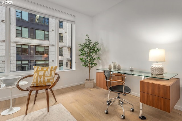 office area featuring baseboards and light wood finished floors