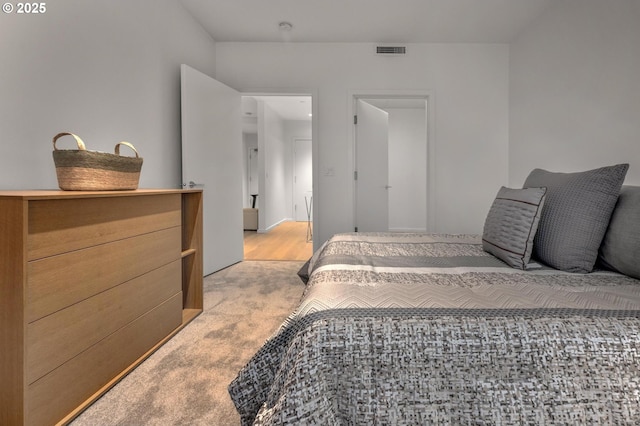 bedroom featuring visible vents and light carpet