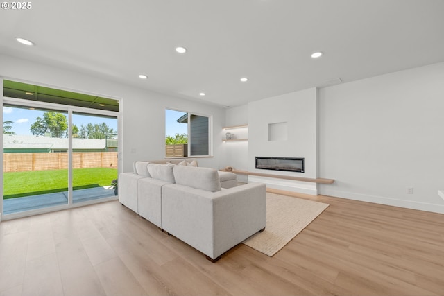 619 E Heintz St, Molalla, OR 97038 - living room featuring light wood-type flooring, plenty of natural light, recessed lighting, and a glass covered fireplace