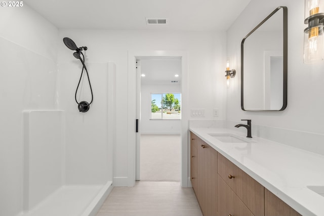 619 E Heintz St, Molalla, OR 97038 - bathroom featuring vanity, a shower, and wood finished floors